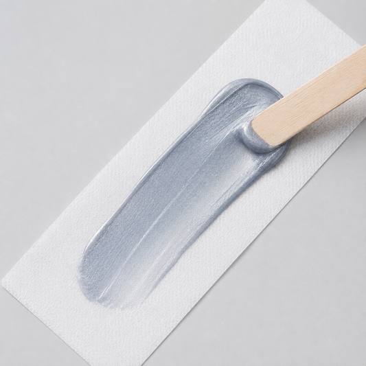 Natural Look Silver Sensation strip wax spread on a waxing strip with a wooden spatula