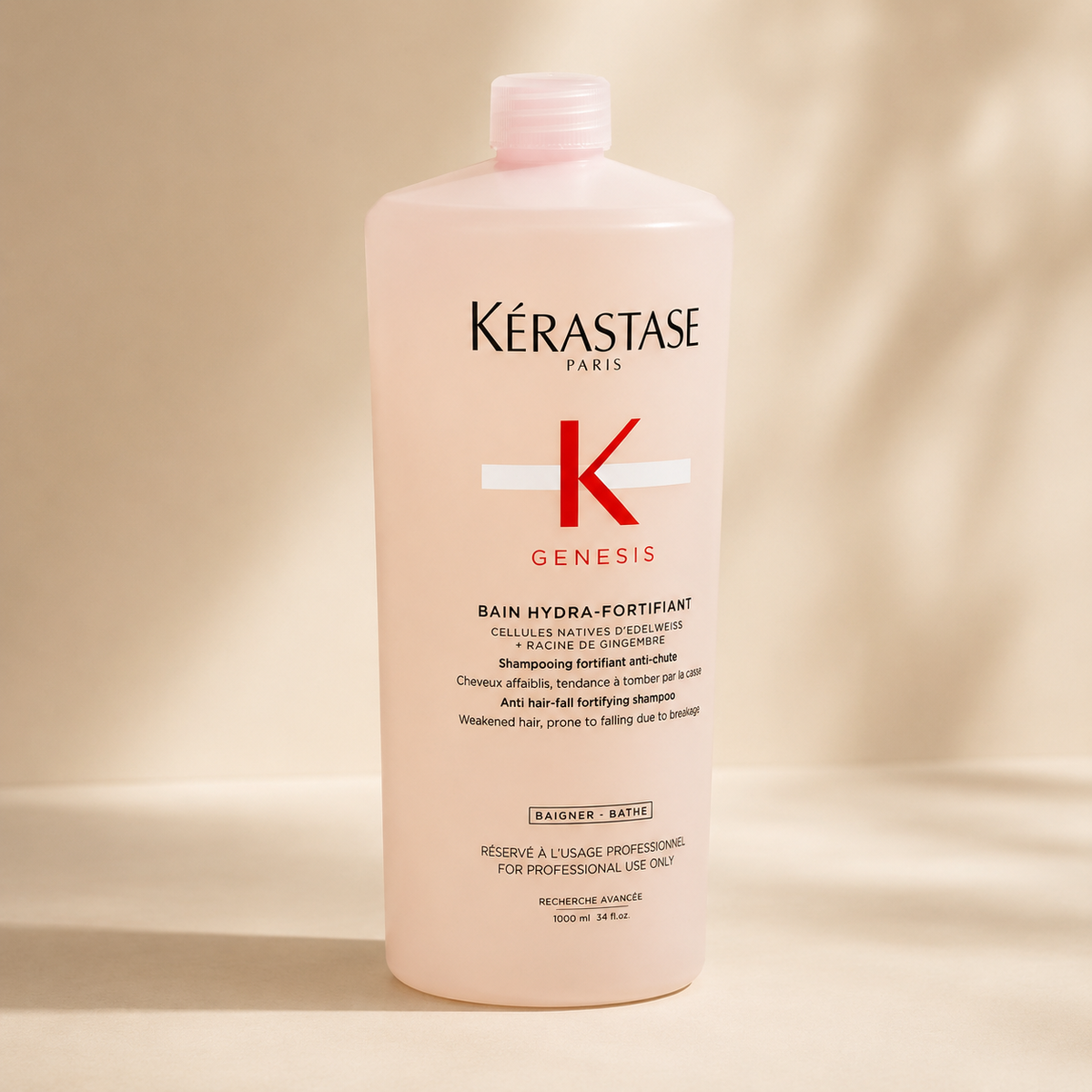 Kérastase Genesis Bain Hydra-Fortifiant 1000ml bottle on a stone plinth in warm light