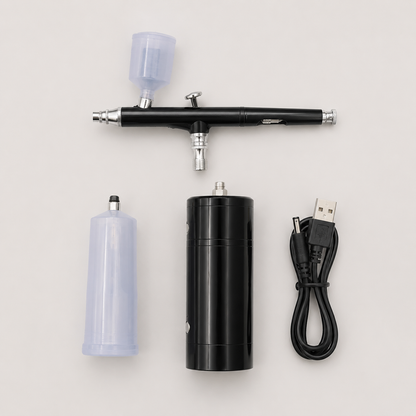 Black portable airbrush kit contents including compressor, airbrush, two cups and USB cable