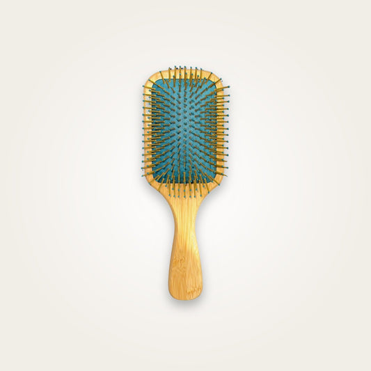MV rectangular paddle brush with wooden-tone handle and teal cushion on a light studio background