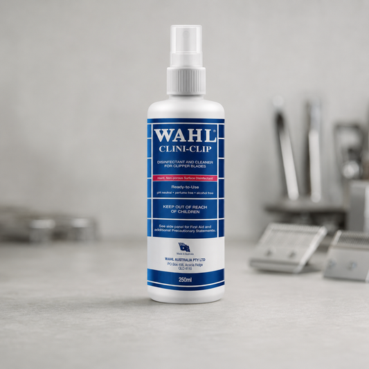 Wahl Clini-Clip 250ml disinfectant spray bottle on a salon worktop