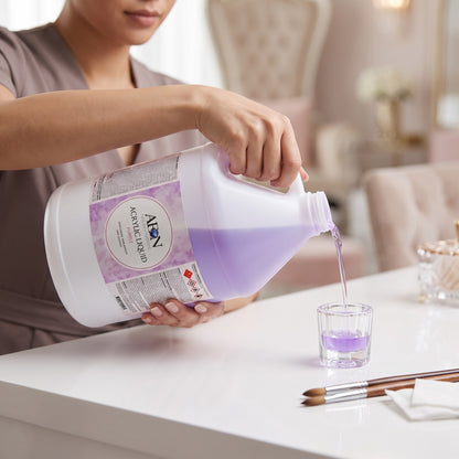 Nail technician pouring AEON acrylic nail liquid into a dish
