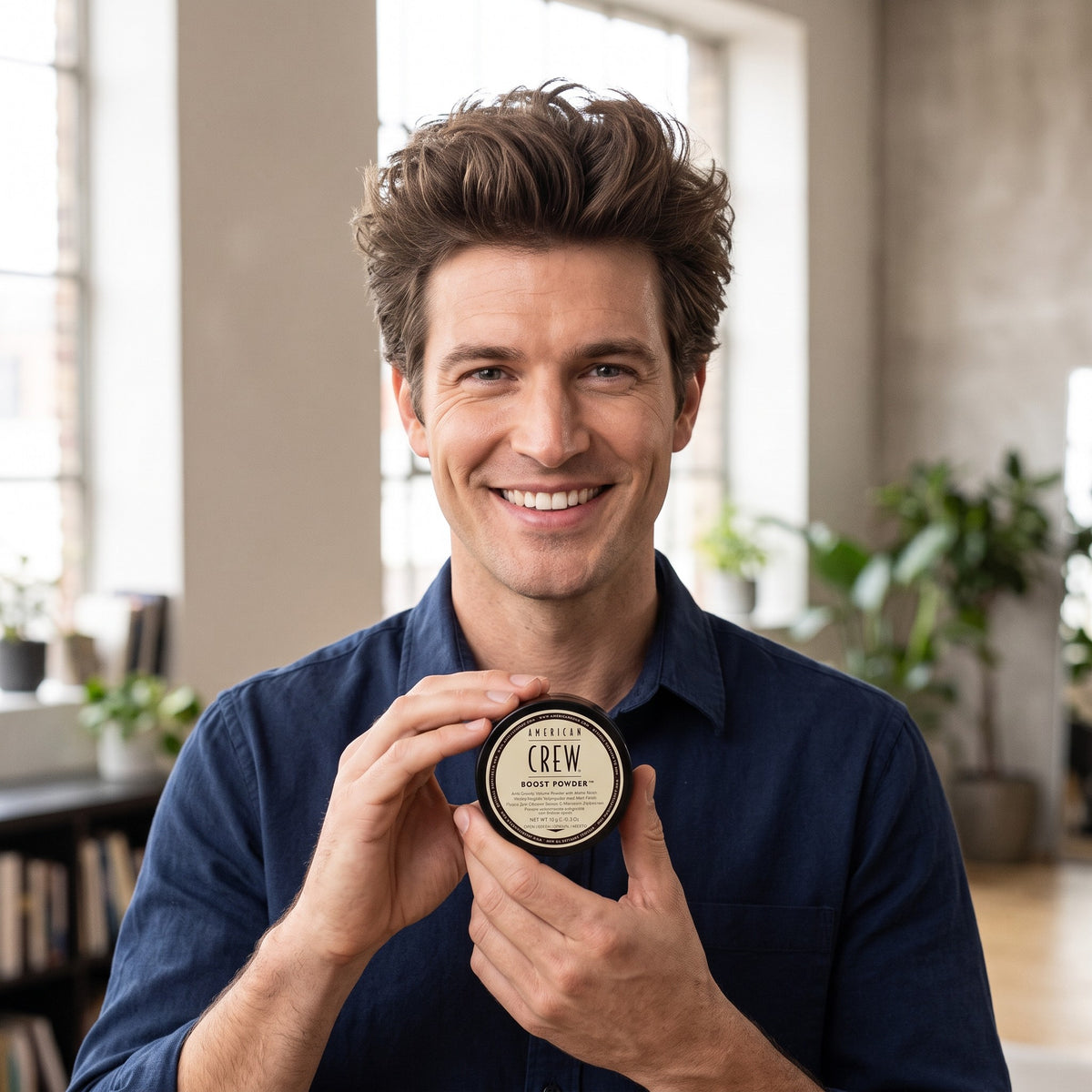 Smiling man holding American Crew Boost Powder