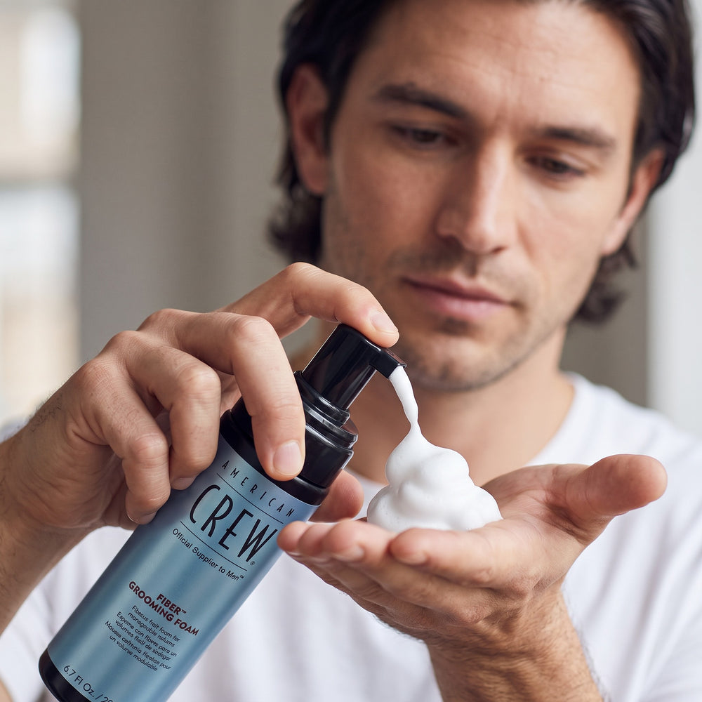Man dispensing American Crew Fiber Grooming Foam into his hand