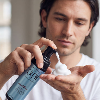 Man dispensing American Crew Fiber Grooming Foam into his hand