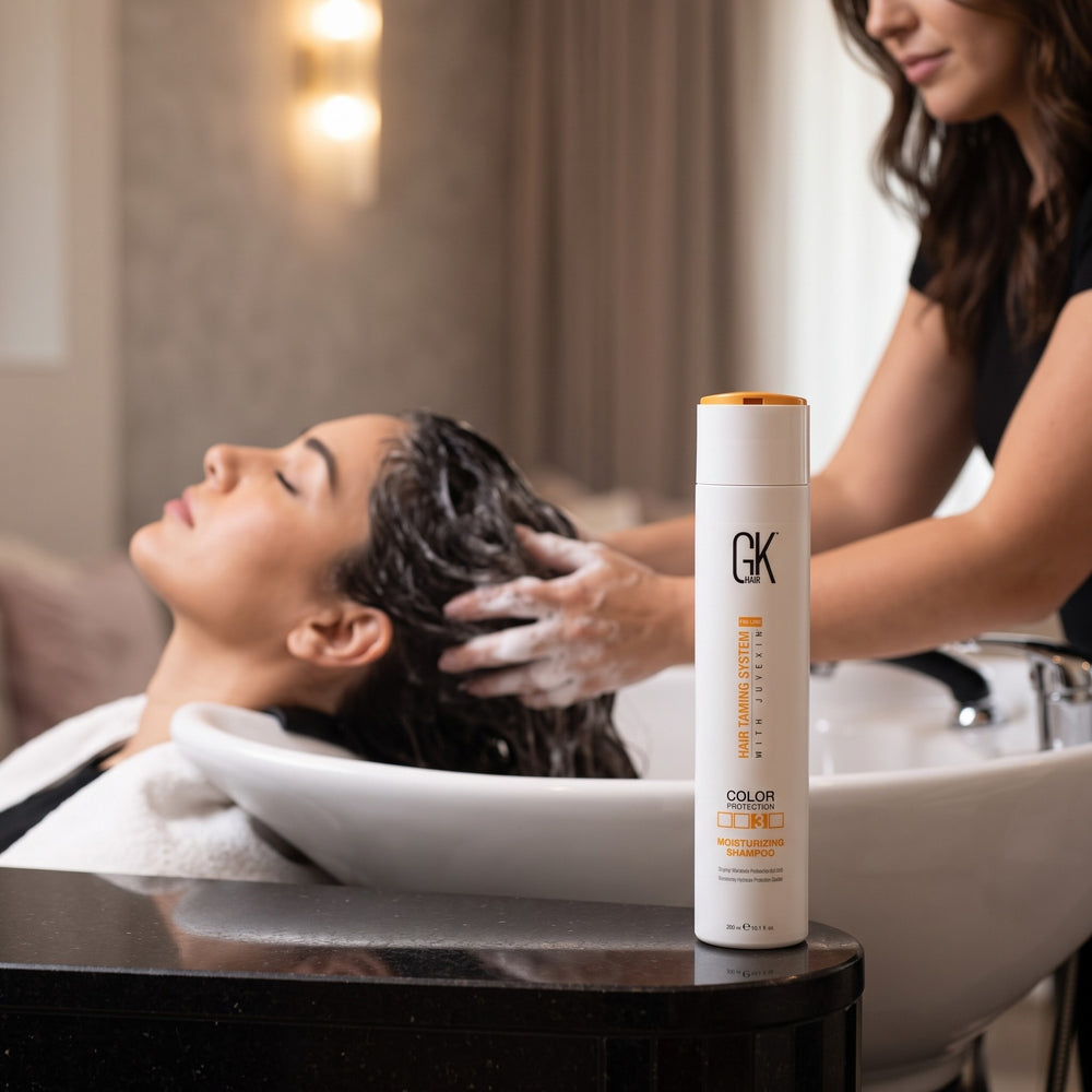 Stylist washing a client's hair with GK Hair Moisturizing Shampoo