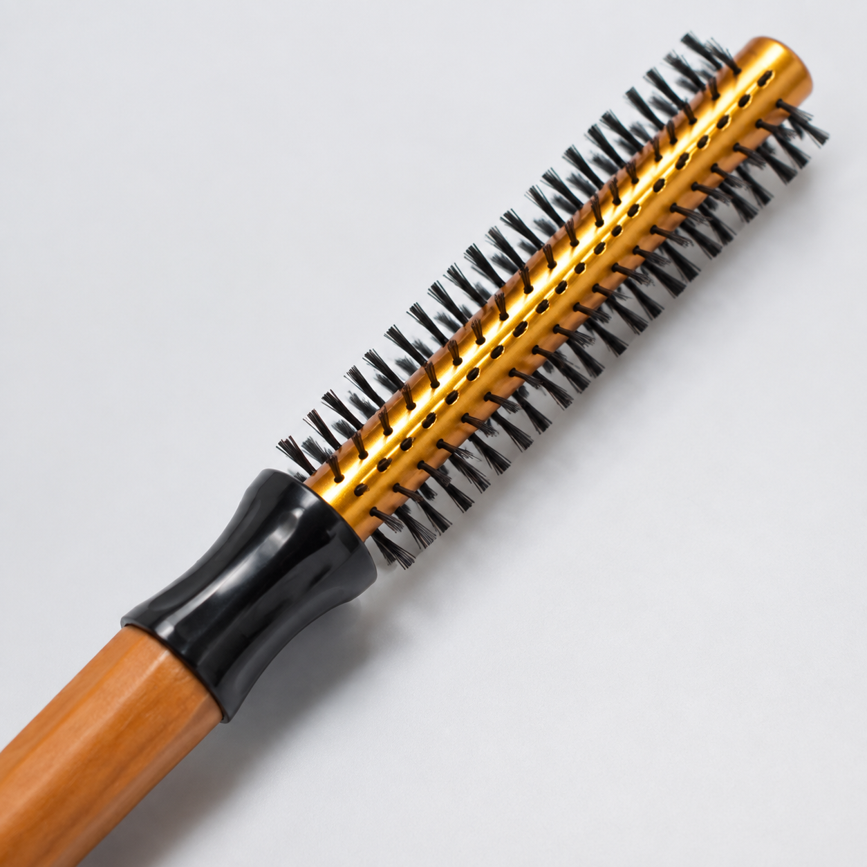 Gold 13mm vented round brush barrel and black bristles close-up