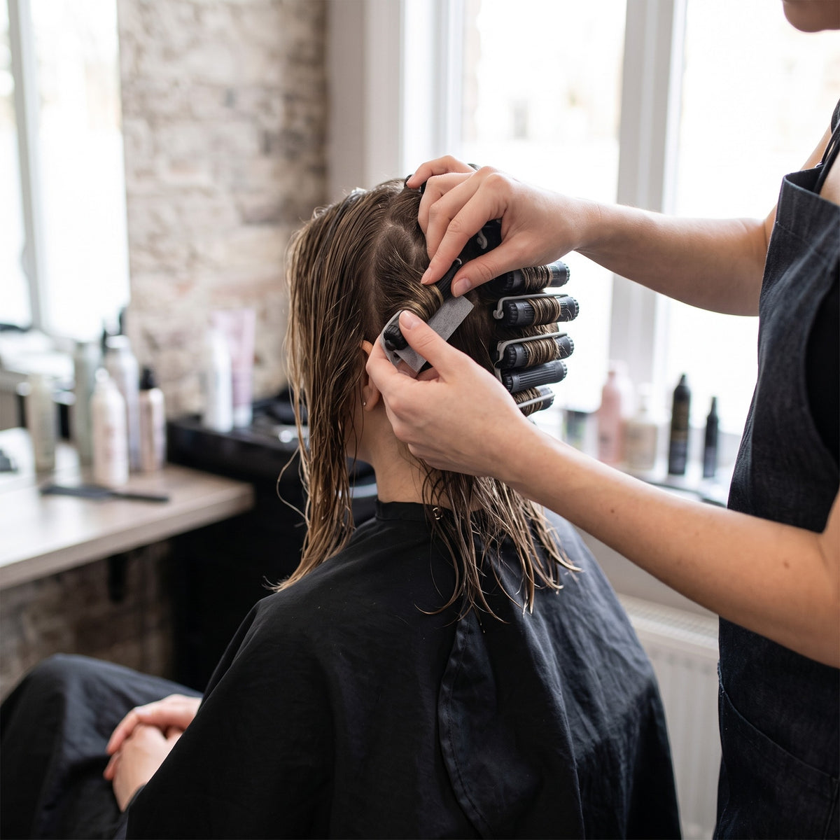 Stylist winding hair onto Hair FX perm rods