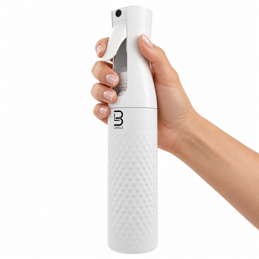White L3VEL3 beveled spray bottle held at the trigger in a salon