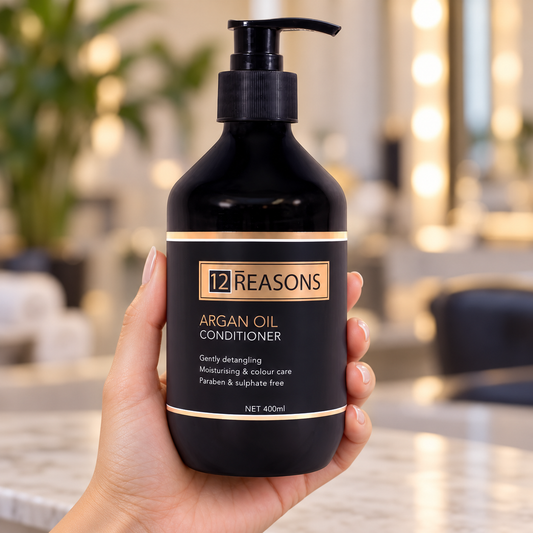 12 Reasons Argan Oil Conditioner 400ml pump bottle held with the front label visible.