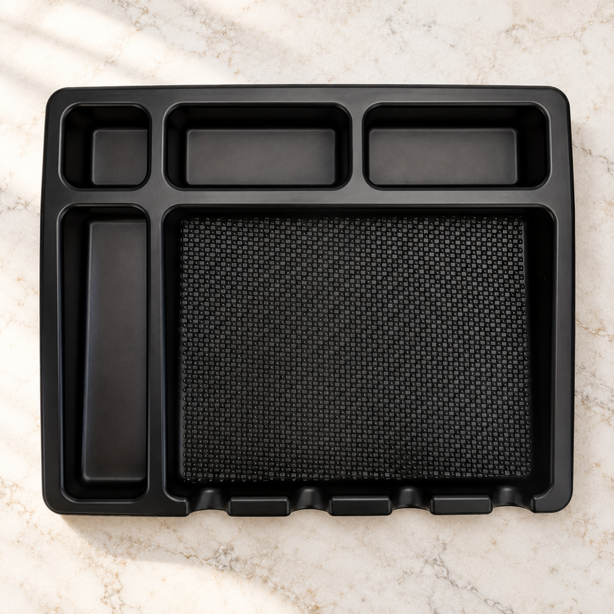 Black barber tools tray with five empty compartments on a salon workstation