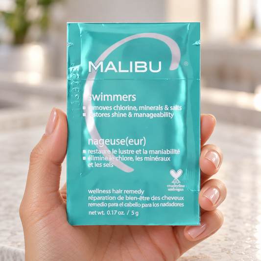 Malibu C Swimmers Wellness Remedy 5g sachet held in a salon, showing the sealed pack and front label.