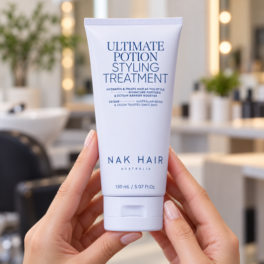 NAK Ultimate Potion 150ml tube held upright in a salon, showing its front label and closed cap