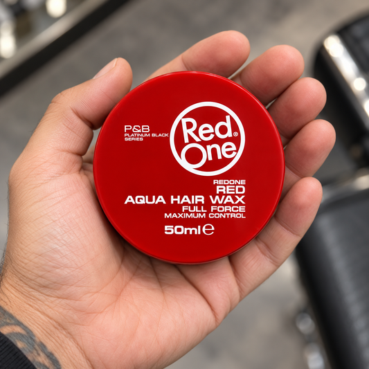 RedOne Full Force Red Aqua Hair Wax 50ml closed tub held in a barber’s palm, with the lid label visible