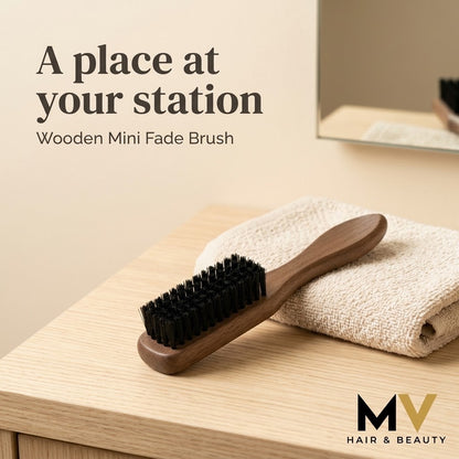 Wooden mini fade brush beside a folded towel on a pale wood barbershop counter, with A place at your station caption and small blended MV logo. AI-created lifestyle presentation.