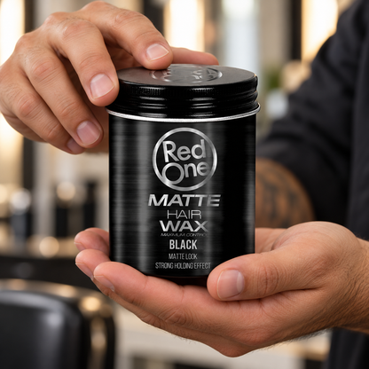 Hands holding the closed RedOne Matte Hair Wax Black 100ml tin.