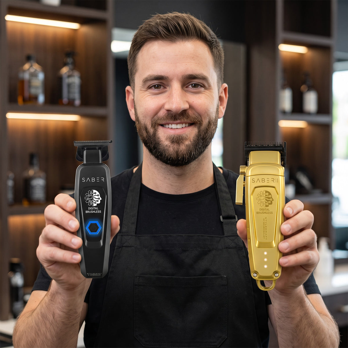Barber holding the StyleCraft Saber 2 gold clipper and black Precision trimmer