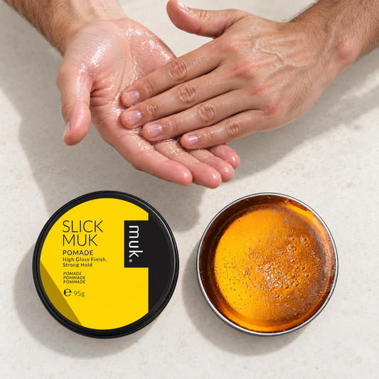 Hands emulsifying Slick muk Pomade until clear beside the open 95g tin and lid.