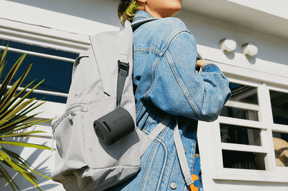 Sony SRS-XB100 Black portable speaker attached to a backpack with its strap